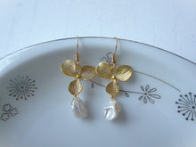 Load image into Gallery viewer, Gold butterfly earrings with pearl drops on a decorative plate.
