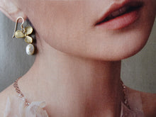 Load image into Gallery viewer, Close-up of a person wearing gold earrings with leaf design and pearl drop.