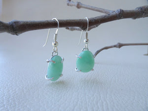 green jade earrings hanging from twig